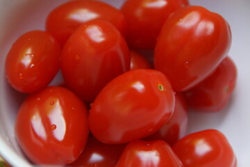 A stunning display of cherry tomatoes in vibrant colors, ranging from bright red to golden orange. Fresh and juicy, they catch the light, highlighting their natural shine and smooth texture.