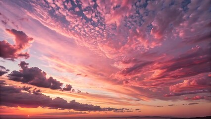 A photograph capturing a breathtaking view of a sunset with a sky filled with a beautiful array of pink-tinged clouds.