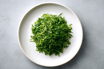 Fototapeta premium Freshly chopped green herbs on white plate, perfect for garnishing dishes
