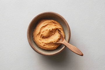 Creamy miso paste in bowl with wooden spoon, perfect for culinary use and flavor enhancement