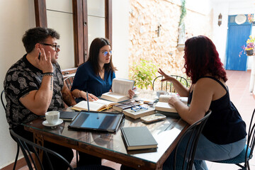 Writers discussing literature and sharing ideas at a cafe table