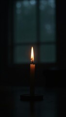 A single candle illuminates a dark room.