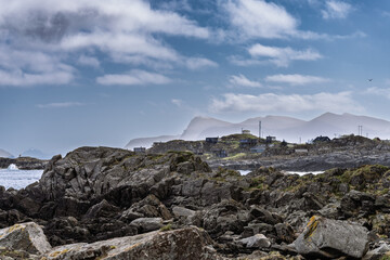Scenic Coastal View with Mountains and Rocks Under Dramatic Cloudy Sky, Runde, Norway