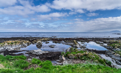 Peaceful Coastal Landscape with Ocean and Rocky Shoreline Under Blue Sky, Runde, Norway