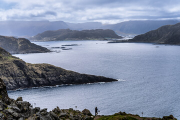 Scenic Coastal View of Rugged Cliffs and Calm Blue Waters Under Cloudy Skies, Runde, Norway
