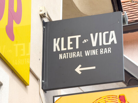 Ljubljana, Slovenia - June 03, 2025: Klet Vica natural wine bar sign hanging on building exterior, showcasing vibrant colors and inviting atmosphere for wine enthusiasts and visitors