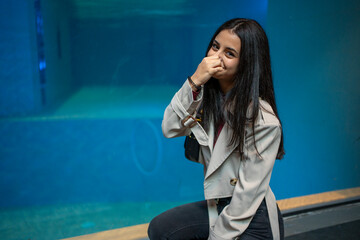 Young woman holding her nose because of bad smell coming from the aquarium