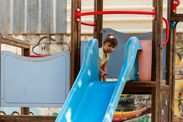 Child playing on a slide in a colorful playground surrounded by vibrant artwork
