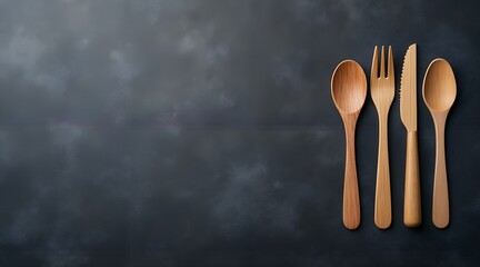 Wooden spoon fork and knife on dark background