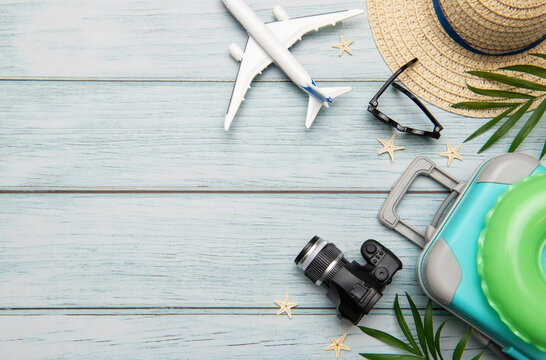 Travel accessories lying on wooden background for summer vacation trip - Powered by Adobe