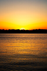 fiery sunset over the lake on a clear summer evening