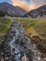 Serene stream flowing through rocky mountain valley