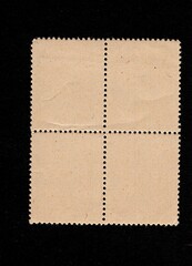Obraz premium The backs of postage stamps isolated on a black background.