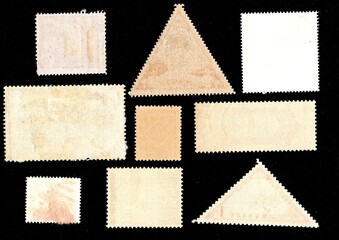 The backs of postage stamps isolated on a black background.