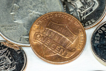 One US Dollar Cent with different currency coins on white background