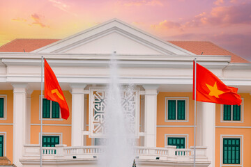 Majestic government building with Vietnamese flags at sunset in Hanoi