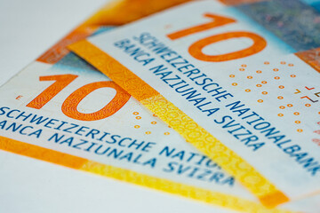 Two ten swiss franc bank notes showing values on white background