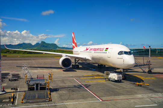 Plaine Magnien, Mauritius - February 25, 2025 : Air Mauritius jet at Sir Seewoosagur Ramgoolam International Airport, with lush rainforest and mountain views in the background.