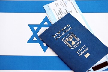 Israel passport and tickets on flag. The current Israel biometrical pass lies on flag close up. The...
