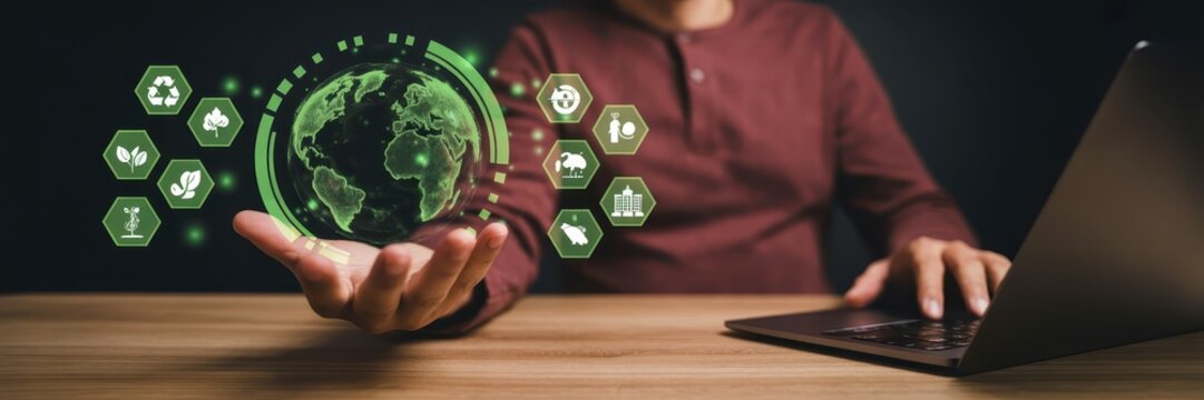 Holographic globe with sustainability icons displayed in a hand. - Powered by Adobe