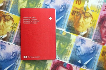 Swiss franc banknotes and passport. The current francs money bills and biometrical pass lies on...