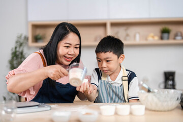 Family Cooking Fun. A mother and son measuring ingredients together in the kitchen.