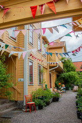 Inner garden decorated with flags, green bushes growing. Celebration