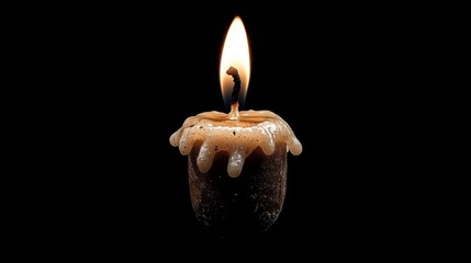 A single candle with a black wick and a brown wax base.