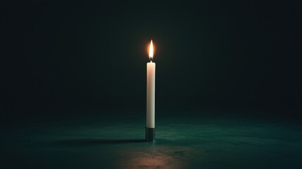A single white candle with a black base stands on a dark green surface.