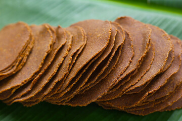 Fermented soybean discs, known as “Thua Nao,” a traditional Thai seasoning used to enhance...