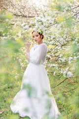 Bride in a white dress among blossoming apple trees, gentle light, spring freshness, romantic...