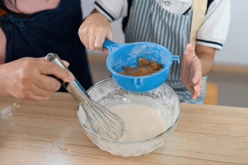 Family Cooking Together. A mother and son preparing a recipe in the kitchen, fostering bonding...