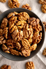 Raw Walnut Halfs in a Bowl, top view. Flat lay, overhead. Close-up.