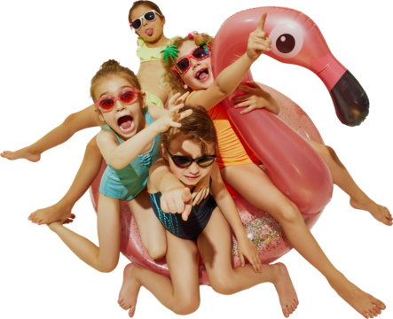 A group of kids in swimsuits and sunglasses excitedly point and laugh while piled on a pink inflatable flamingo. Concept of childlike joy, festival atmosphere and summer event promotion