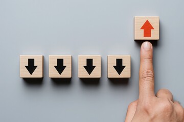 Upward Trend A Finger Points to an Upward Arrow Block Among Downward Arrows Symbolizing Growth and Positive Direction on Gray