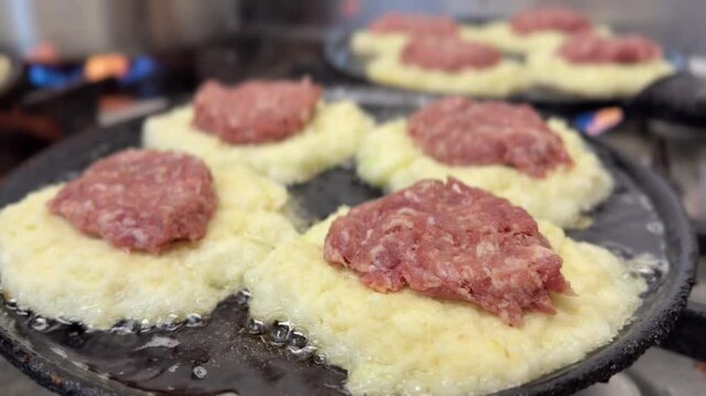 Potato pancake with meat frying on a pan. Closeup