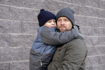 Father and son walking down on sidewalk together. Portrait of a handsome middle-aged man with...
