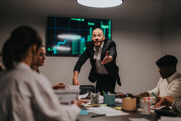 A group of professionals engaging in a discussion about financial growth shown on a screen. The meeting emphasizes teamwork, strategy, and business development in a collaborative office environment.