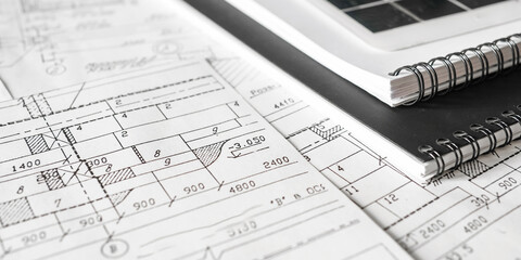 sustainable architecture tools and materials: blueprints, solar panel, wood textures, fabric swatches, and stones. Eco-friendly design, conscious construction and green innovation.	