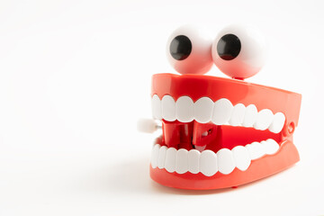 Tooth funny toy denture red color jaw and eye on white background with copy space.