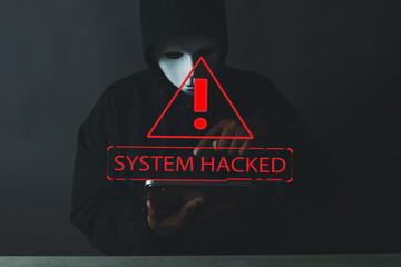 Technology idea.,An anonymous hacker in a mask and hoodie with a 'System Hacked' warning message....