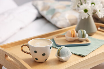 Tray with delicious breakfast and flowers on bed indoors, closeup. Space for text