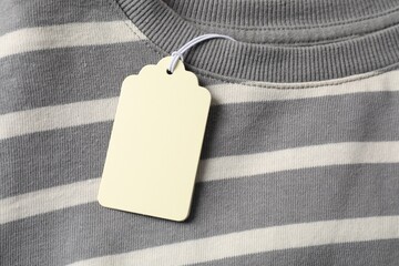 Cardboard tag on striped garment, top view