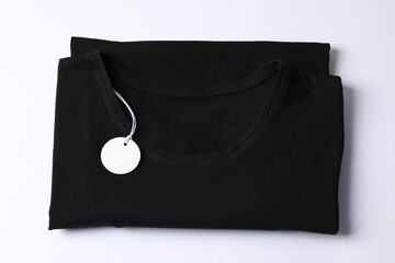 T-shirt with tag on white background, top view
