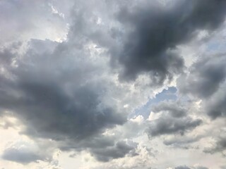 Dramatic cloudy sky with scattered sunlight and blue patches