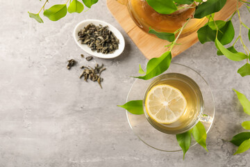 Refreshing green tea with lemon and leaves on light table, flat lay. Space for text