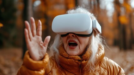 An elderly woman experiences the excitement of virtual reality, immersed in technology, joyfully interacting with her surroundings amidst a beautiful autumn forest.