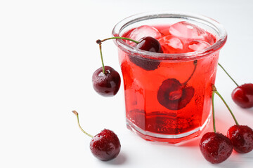 Tasty cherry soda with ice cubes and berries on white wooden table, closeup. Space for text