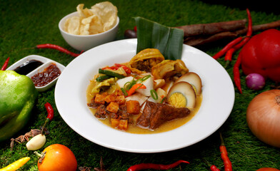 Savor this delicious Indonesian combination: tender Ketupat rice cakes paired with a flavorful, aromatic Opor Sayur vegetable curry