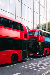 Red double-decker buses parked on london street near modern building